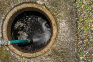 A highly-pressurized stream of water being directed into a drain.
