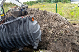 A septic tank being installed with an excavator.
