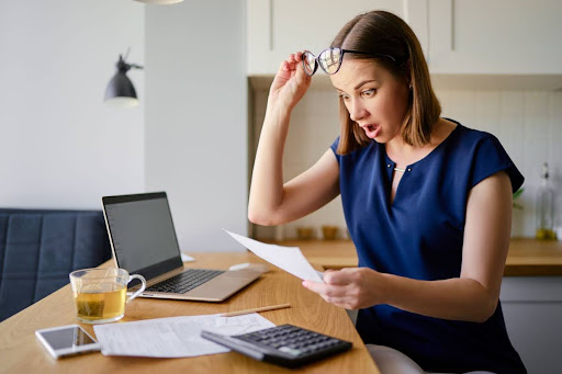A shocked woman looking at a bill.